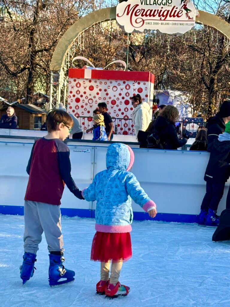 Young girl and boy ice skating in Milan, Italy