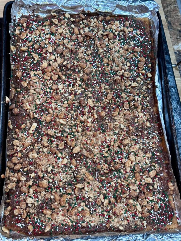 Close up of Christmas crack with chocolate peanuts and holiday sprinkles.