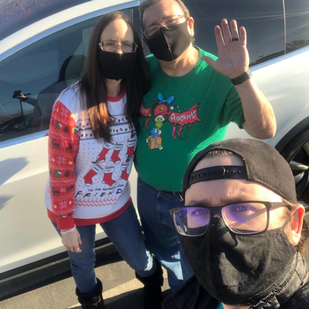 Exchanging Christmas gifts in a grocery store parking lot in 2020 during Covid.
