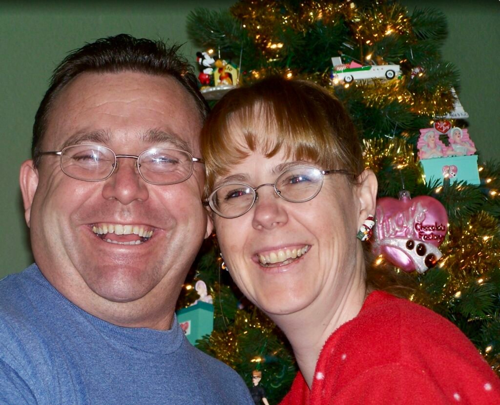 Happy couple on Christmas morning in front of the Christmas tree